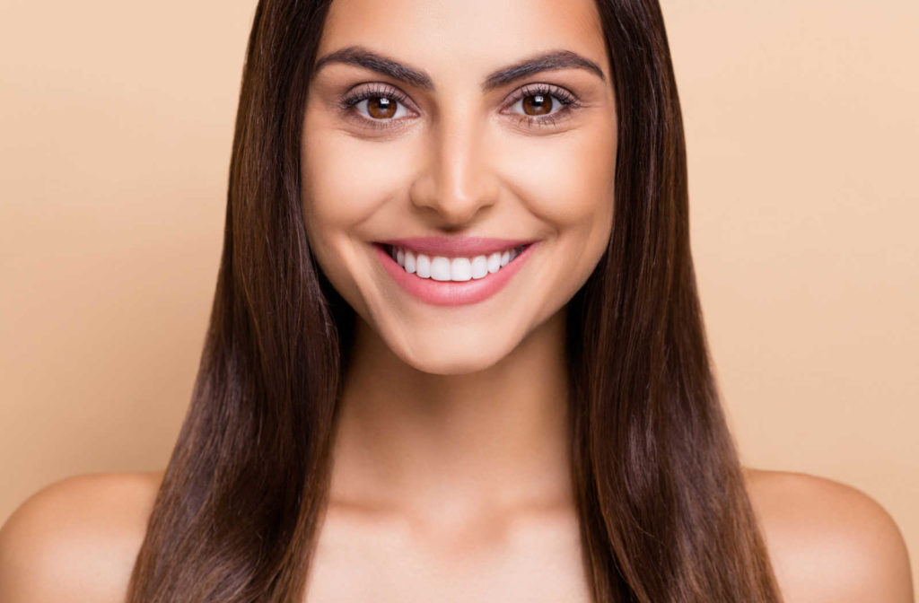 A photo of a lady smiling and showing he beautiful teeth with veneers.