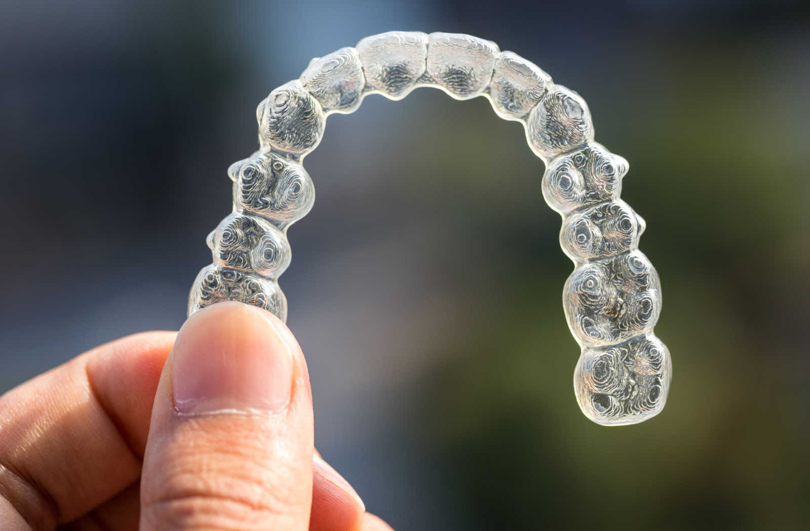 A close-up of a  transparent aligner plastic braces for straightening teeth.